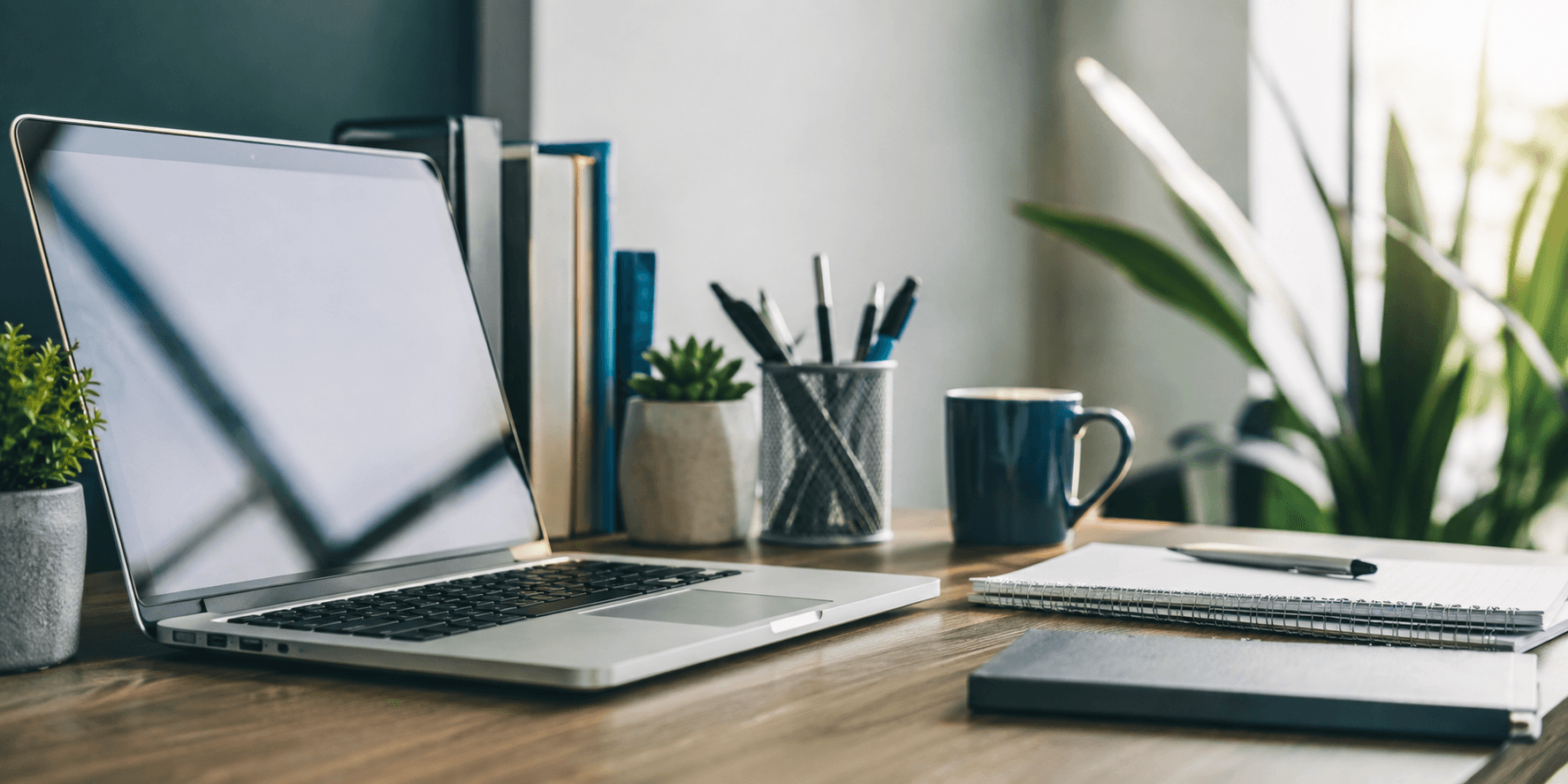 Desk with notebook and laptop for contacting CodingCloud
